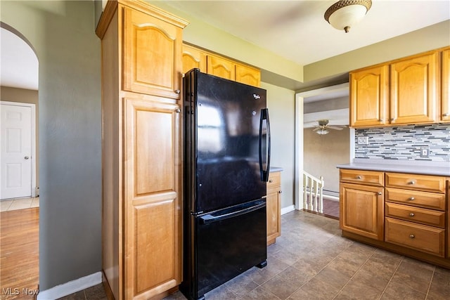 kitchen with black refrigerator, ceiling fan, and backsplash