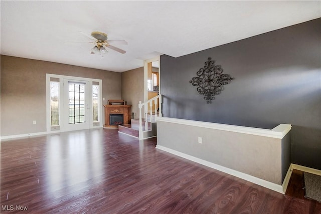 unfurnished living room with dark hardwood / wood-style floors and ceiling fan