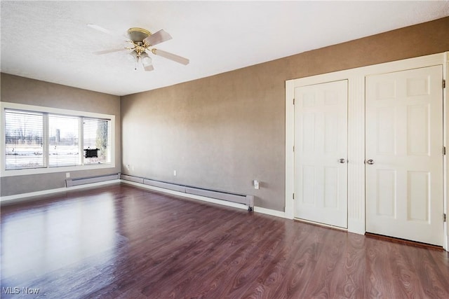 unfurnished bedroom with ceiling fan, dark hardwood / wood-style floors, and a baseboard heating unit