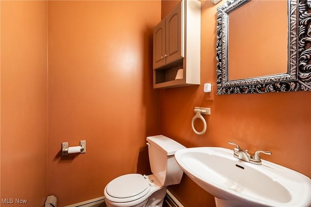 bathroom featuring sink, baseboard heating, and toilet