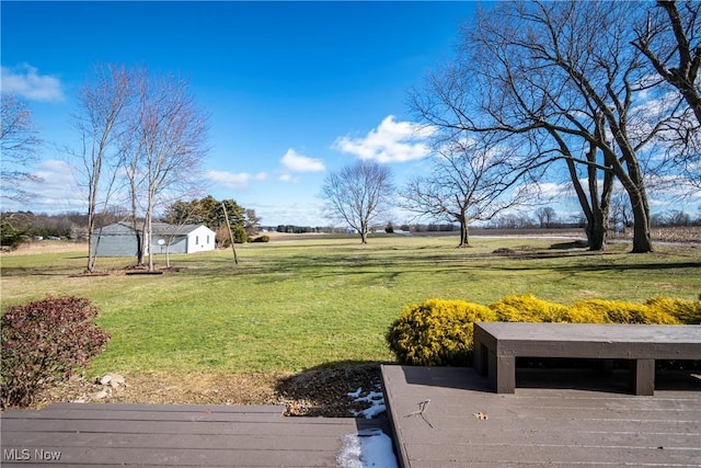 view of yard with a storage shed, a deck, and a rural view