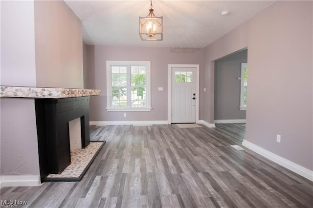 unfurnished living room with a tile fireplace and wood-type flooring