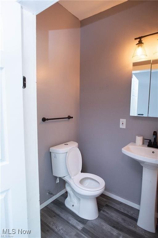 bathroom featuring sink, hardwood / wood-style floors, and toilet