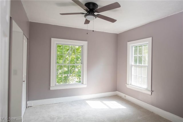 carpeted spare room featuring ceiling fan