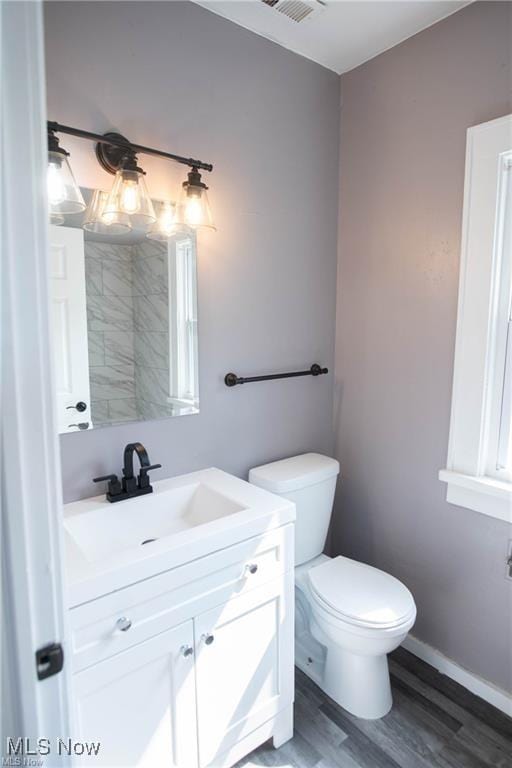 bathroom with vanity, hardwood / wood-style flooring, and toilet