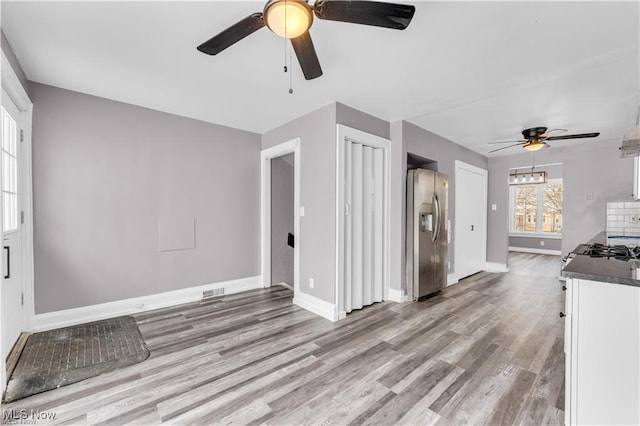 unfurnished living room with ceiling fan and light wood-type flooring