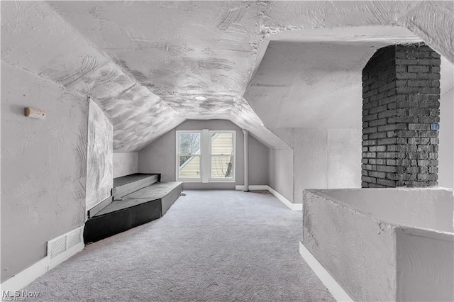 bonus room featuring lofted ceiling and carpet flooring