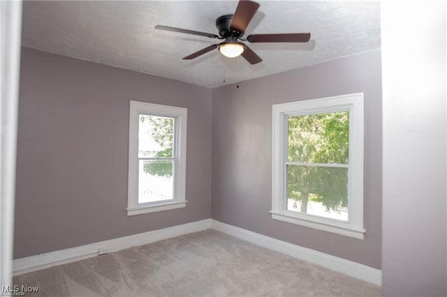 carpeted empty room featuring ceiling fan and a textured ceiling