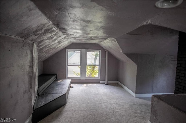 additional living space featuring lofted ceiling and light carpet