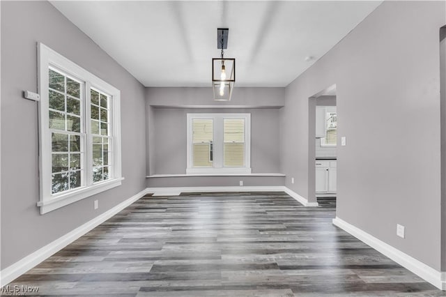 unfurnished dining area with dark wood-type flooring