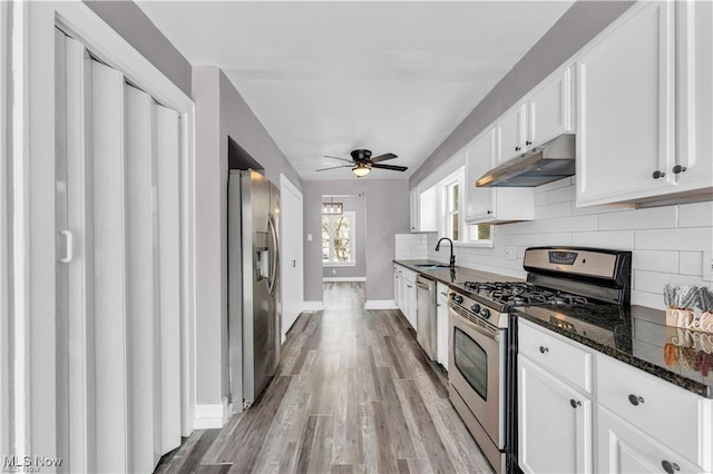 kitchen with white cabinetry, sink, dark stone counters, and appliances with stainless steel finishes