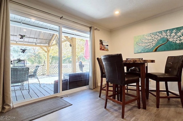 dining room with hardwood / wood-style floors and ornamental molding