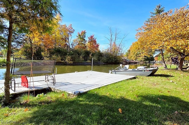 view of dock with a water view and a yard