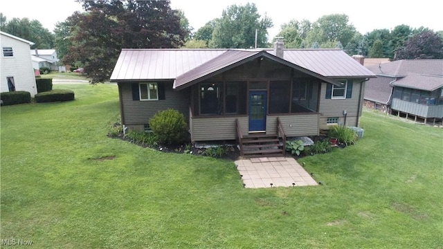 view of front facade with a front yard and a sunroom