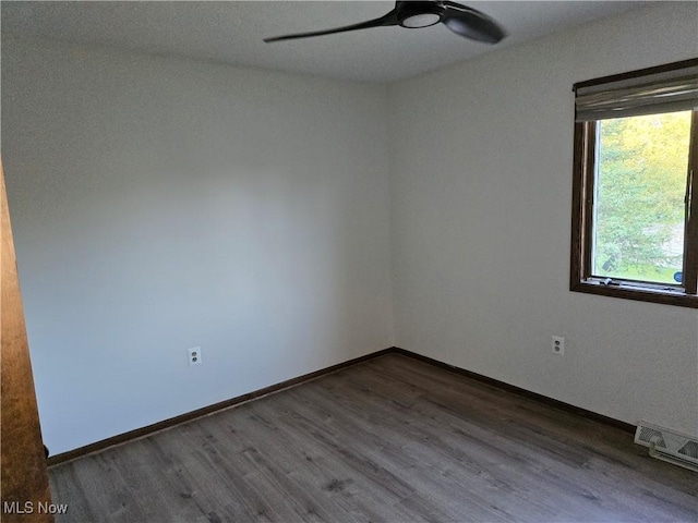 empty room featuring dark hardwood / wood-style floors and ceiling fan