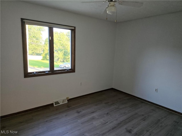 spare room featuring ceiling fan and dark hardwood / wood-style flooring