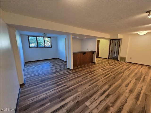 spare room with dark wood-type flooring and a textured ceiling