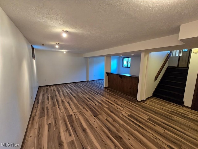 basement with dark hardwood / wood-style flooring and a textured ceiling