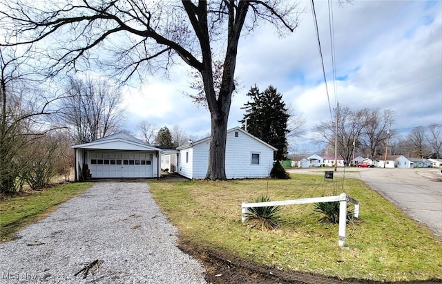 exterior space featuring a garage, an outbuilding, and a front lawn