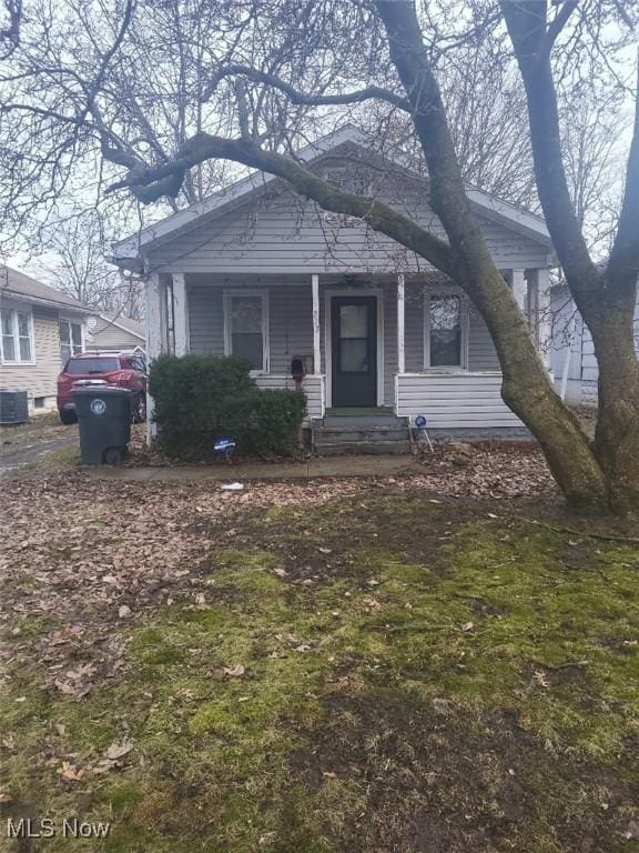 bungalow with central AC unit and a front lawn