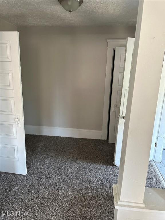 carpeted spare room featuring a textured ceiling