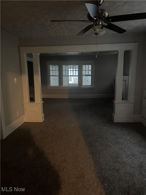 spare room featuring dark colored carpet, a textured ceiling, and ceiling fan