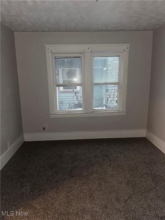 empty room featuring dark colored carpet