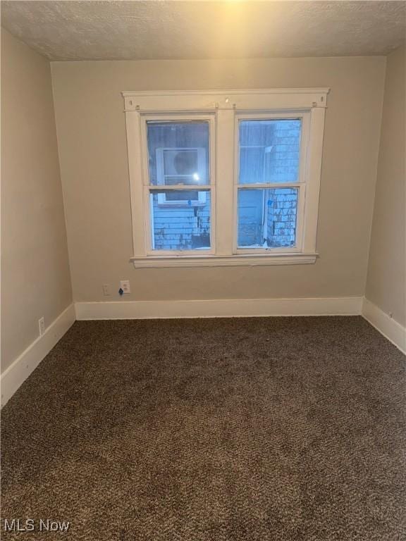 empty room with carpet and a textured ceiling