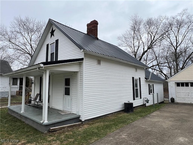 exterior space with a garage, an outbuilding, and covered porch