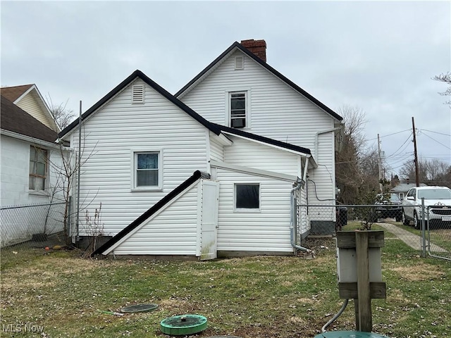 rear view of house featuring a lawn