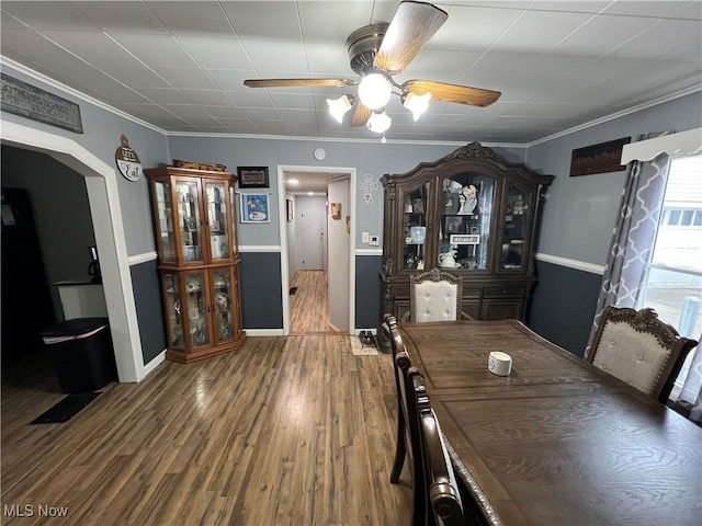 unfurnished dining area with wood-type flooring, ceiling fan, and crown molding