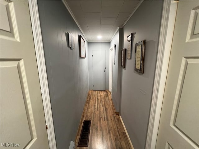 hallway with hardwood / wood-style flooring and ornamental molding