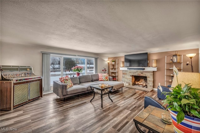 living room featuring hardwood / wood-style flooring, a fireplace, and a textured ceiling