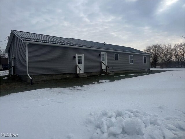 view of snow covered back of property