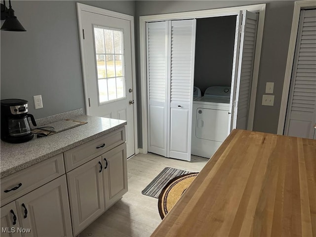 washroom featuring washing machine and dryer and light wood-type flooring