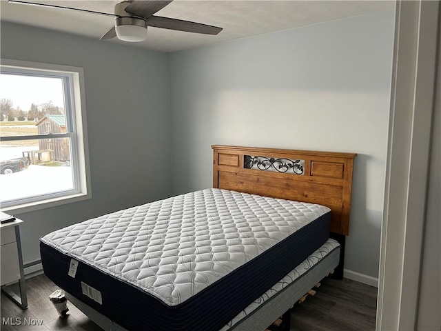 bedroom with dark hardwood / wood-style floors and ceiling fan