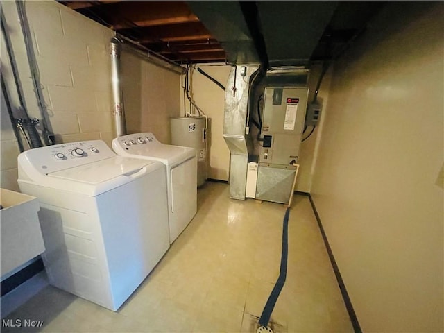 laundry room with laundry area, independent washer and dryer, electric water heater, and heating unit