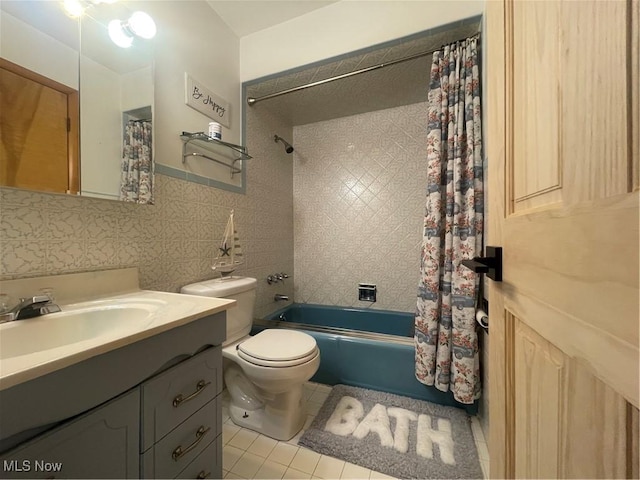 bathroom featuring tile patterned flooring, toilet, vanity, tile walls, and shower / bath combo