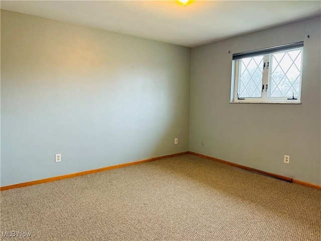 carpeted empty room with baseboards