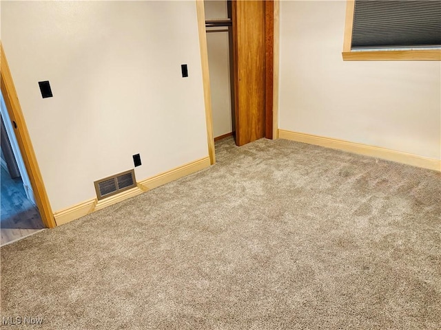 unfurnished bedroom with a closet, carpet flooring, visible vents, and baseboards