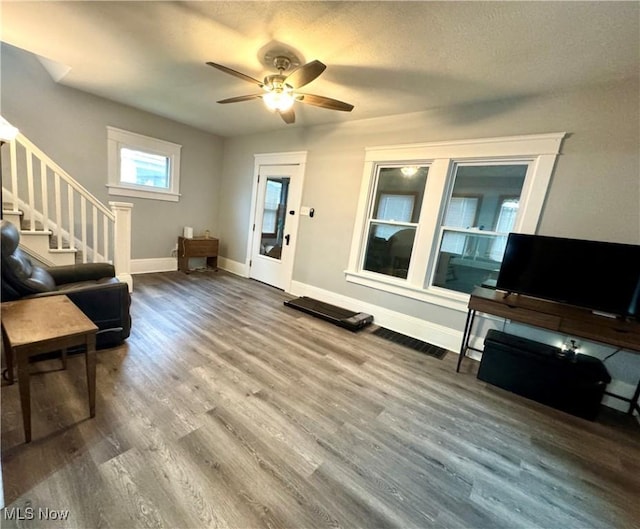 588 Robinette Ct, Akron, OH 44310 - living room featuring stairway, wood finished floors, ceiling fan, and baseboards