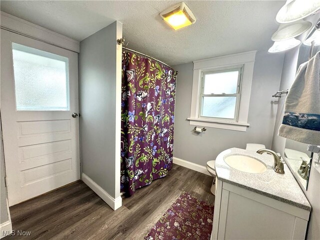 588 Robinette Ct, Akron, OH 44310 - full bath featuring vanity, wood finished floors, baseboards, toilet, and a textured ceiling