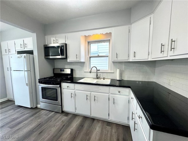 kitchen featuring stainless steel appliances, sink, white cabinets, and dark hardwood / wood-style floors