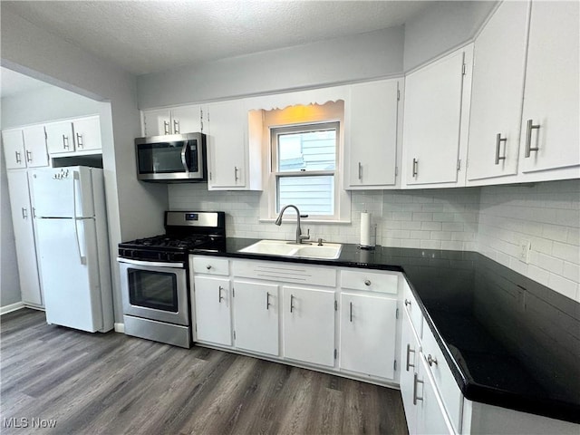588 Robinette Ct, Akron, OH 44310 - kitchen featuring stainless steel appliances, a sink, dark wood finished floors, white cabinetry, and a textured ceiling