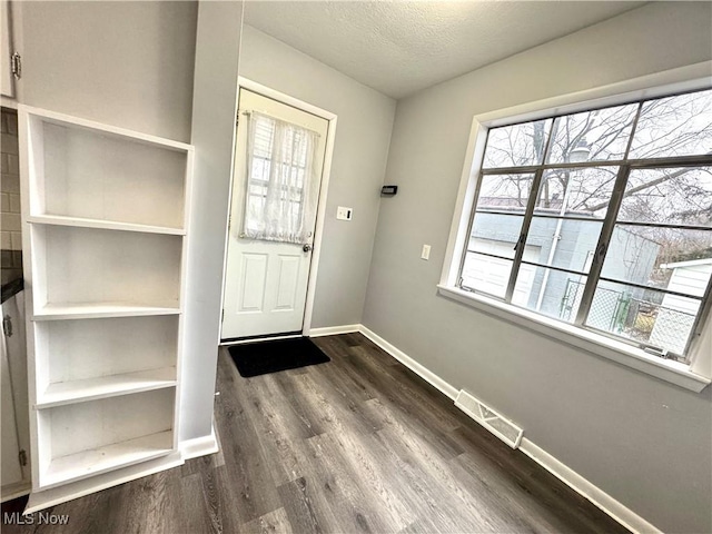 doorway to outside featuring hardwood / wood-style flooring and a textured ceiling