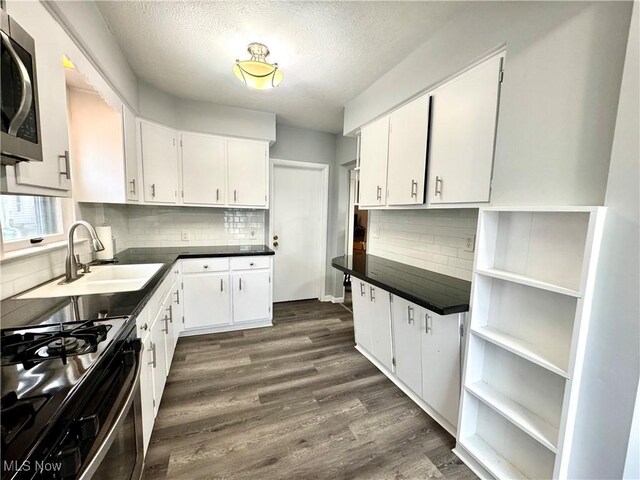 588 Robinette Ct, Akron, OH 44310 - kitchen with black gas stove, stainless steel microwave, backsplash, dark wood-type flooring, and dark countertops