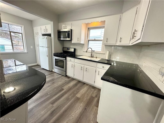 kitchen featuring stainless steel appliances, dark hardwood / wood-style floors, sink, and white cabinets