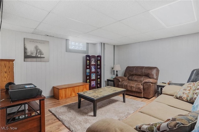 living room featuring a paneled ceiling and light hardwood / wood-style floors