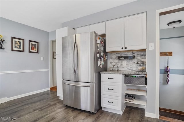 kitchen featuring dark hardwood / wood-style floors, stainless steel fridge, decorative backsplash, and white cabinets