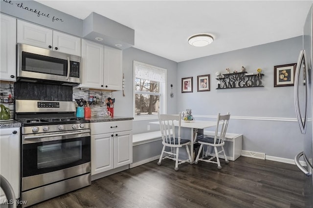 kitchen featuring appliances with stainless steel finishes, white cabinets, and backsplash